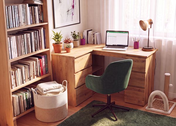 Kotitoimisto, jossa on puinen kulmaty&ouml;p&ouml;yt&auml;, ergonominen vihre&auml; ty&ouml;tuoli, kannettava tietokone, kirjahylly, p&ouml;yt&auml;valaisin ja viherkasveja. Se luo mukavan ja tehokkaan ty&ouml;tilan et&auml;ty&ouml;h&ouml;n.