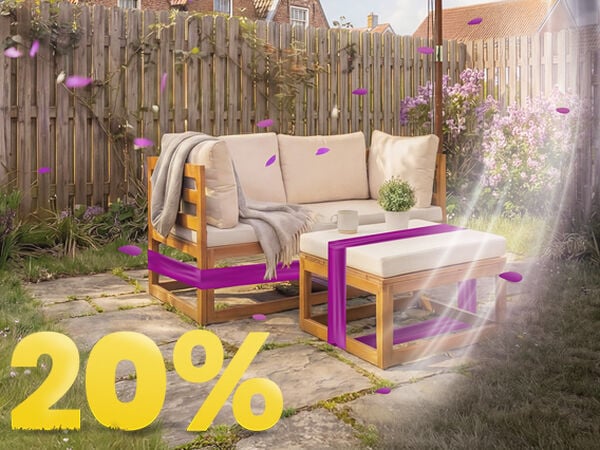 Puinen puutarhasohva beigeill&auml; tyynyill&auml; ja p&ouml;yd&auml;ll&auml; aurinkovarjon alla aurinkoisella terassilla, kukkien ja aidan ymp&auml;r&ouml;im&auml;n&auml;, 20 % kev&auml;tkampanjabannerilla.