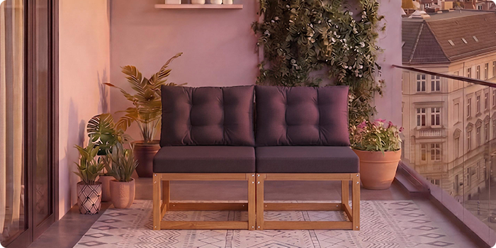 Kaksipaikkainen modulaarinen puusohva tummanharmaille tyynyille parvekkeella ruukukkien ja kaupunkinäkymän kanssa taustalla